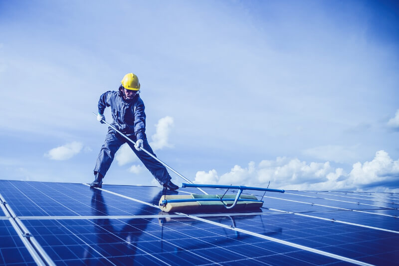 A man cleaning solar panels